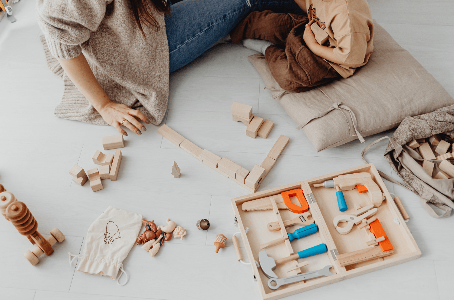 Child Playing with Wooden Toys and Adult